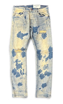 Light-wash distressed denim jeans with blue bleach splatter and yellow distressing, shown flat against a white background. By Fresh N Fitted.