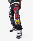 Black wash denim jeans by VOYAGE STUDIO featuring straight fit and patch artwork, shown laid flat.
