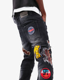 Black wash VOYAGE STUDIO straight fit denim jeans with patch artwork, displaying details of the denim fabric and stitching.