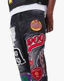 Black wash denim jeans by VOYAGE STUDIO with straight fit and patch artwork, shown on a model.