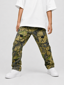 A child wearing camouflage cargo pants with a white t-shirt and white sneakers, shown from the chest down against a light gray studio background.
