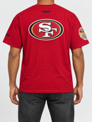 Red Pro Standard San Francisco 49ers drop shoulder T-shirt featuring bold team logo and "Living Large" design on front.