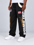 Men's black Copper Rivet windbreaker sweatpants with rivet details, angled view showcasing nylon fabric and sporty style.