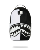 A black and white spray-painted backpack featuring a shark mouth graphic across the lower half, shown against a plain white background. By Fresh N Fitted