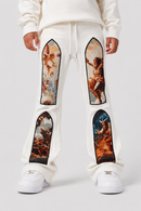A person wearing cream sweatpants with large classical painting panels on the thighs and lower legs, paired with white sneakers, shown from the waist down against a light gray studio background.