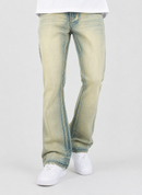 A person wearing light-wash, faded blue jeans with a straight-to-relaxed leg, styled with a white t-shirt and white sneakers against a light gray studio background.