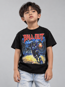 A young boy wearing a black graphic t-shirt with a red 'BALL OUT' text and a basketball player print, paired with light wash jeans, against a solid gray studio background.