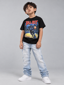 A young boy modeling a black graphic t-shirt with a red 'BALL OUT' text and a space-themed print, paired with light-wash distressed jeans and white sneakers, against a solid gray studio background.