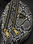 Patterned bag with gold zippers and a brand logo on a dark background