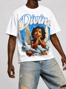 A white graphic t-shirt featuring a large print of a cherub with the word 'Divine' in blue script, worn by a model with distressed denim shorts against a light gray background.