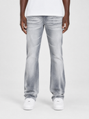 A person wearing light gray washed denim jeans with a straight-to-relaxed leg, paired with a white t-shirt and white sneakers, shown from the waist down on a light gray studio background.