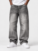 A person wearing very wide-leg gray denim jeans with a heavily faded, wrinkled texture, styled with a white t-shirt and white sneakers against a light gray studio background.