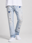 Light wash blue distressed denim jeans with ripped details and frayed edges, shown on a model wearing a white t-shirt and white sneakers against a light gray studio background.