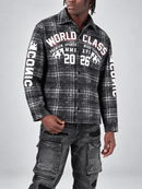 A man wearing a black and white plaid button-up shirt with distressed graphics reading 'WORLD CLASS' and 'COMIC' on the sleeves, paired with dark gray cargo pants, against a light gray studio background.