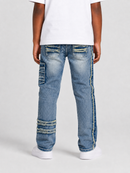 A child viewed from the back wearing light blue distressed denim jeans with decorative frayed details and white sneakers against a light gray studio background.