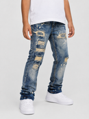A child wearing distressed blue denim jeans with ripped details and white sneakers, shown from the waist down against a light gray studio background.