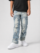 A person wearing light-wash, heavily distressed and ripped blue denim jeans with a black t-shirt and white sneakers, shown from the waist down against a light gray studio background.
