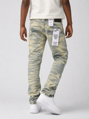 A person shown from the back wearing slim-fit jeans with a distressed yellow and gray wash, a cream t-shirt, and white sneakers against a light gray studio background.