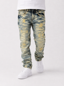 Distressed blue denim jeans with yellow and white faded wash details, shown on a model wearing a white t-shirt and white sneakers against a light gray background.