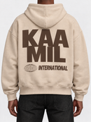 Cream and brown KML INTERNATIONAL boxy hoodie sweatshirt with a relaxed fit and soft fabric, displayed on a plain background.