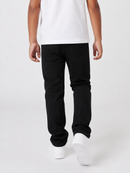 A person shown from the back wearing black jeans, a white t-shirt, and white sneakers against a light gray studio background.