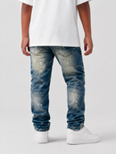 A person shown from the back wearing distressed blue jeans with a faded wash, a white t-shirt, and white sneakers against a light gray studio background.