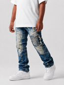 A child wearing distressed blue denim jeans with ripped details and white sneakers, shown from the waist down against a light gray studio background.