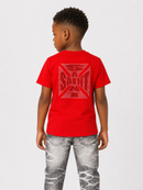 A child model shown from the back wearing a bright red t-shirt with a faded red graphic on the back and distressed gray jeans, set against a plain light gray studio background.