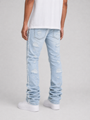 A person shown from the back wearing light-wash distressed jeans with frayed side details, a white t-shirt, and white sneakers against a light gray studio background.