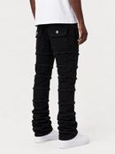 A person shown from the waist down wearing black distressed denim jeans with frayed trim and multiple patch pockets, paired with a white t-shirt and white sneakers, against a plain white studio background.