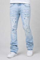 Light wash blue distressed jeans with ripped details on the thighs and knees, shown on a model from the waist down wearing white sneakers against a light gray background.