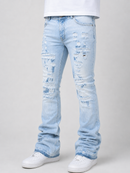 Light wash blue distressed jeans with ripped details on the thighs and knees, shown on a model wearing a white t-shirt and white sneakers against a light gray background.