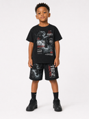 A young boy modeling a black graphic t-shirt and matching black shorts with 'Rise Untitled' artwork, styled with black socks and sneakers against a plain white studio background.