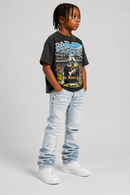 A child model wearing a black graphic t-shirt with a dog print, light-wash distressed jeans, and white sneakers, standing against a light gray studio background. by Fresh N Fitted