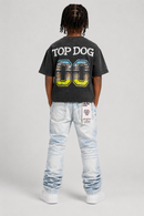 A child model shown from the back wearing a washed black graphic t-shirt with 'TOP DOG' and '00' printed on the back, paired with light-wash jeans and white sneakers, against a light gray studio background. by Fresh N Fitted