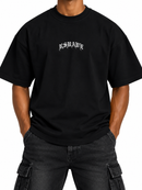 Men's black RSUAVE ‘REALEZA' oversized shirt with center print, casual tee style, front view showing design details.