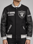 Black Pro Standard Las Vegas Raiders split logo varsity jacket with ribbed cuffs and collar, featuring team embroidery and leather sleeves.