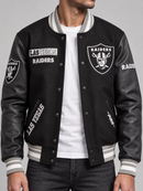 Black Pro Standard Las Vegas Raiders split logo varsity jacket with ribbed cuffs and collar, featuring team embroidery and snap buttons.