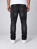 REASON distressed washed black denim jeans with faded and ripped details, showcasing a casual denim style.