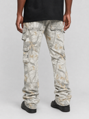 A person shown from the waist down wearing light gray camouflage cargo pants with multiple flap pockets, a black t-shirt, and black shoes, photographed against a light gray studio background.