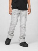 A child wearing light gray distressed denim jeans with ripped details, paired with a black t-shirt and black sneakers, standing against a light gray studio background.