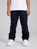 A child wearing dark navy distressed denim jeans with a white t-shirt and white sneakers, shown from the waist down against a light gray studio background.
