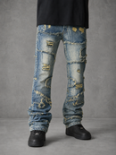 Light blue distressed denim jeans with heavy rips, frayed edges, and faded patches, shown on a model from the waist down against a gray studio background.