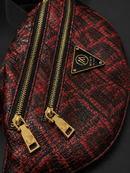 Red and black patterned bag with gold zippers and a brand logo on a dark background