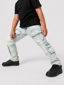 A person wearing light-wash distressed cargo jeans, a black t-shirt, and black sneakers, posed in a wide stance against a light gray studio background.