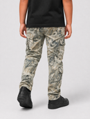 A child wearing camouflage cargo pants, a black t-shirt, and black sneakers, shown from the back against a light gray studio background.