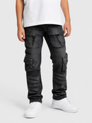 A person wearing washed black cargo jeans with multiple flap pockets, paired with a white t-shirt and white sneakers, shown from the waist down on a light gray studio background.