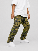 A person wearing green and black camouflage cargo pants, a white t-shirt, and white sneakers, shown from the waist down against a light gray studio background.