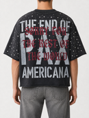 A person shown from the back wearing a black graphic T-shirt with distressed white and red text reading 'THE END OF PAX AMERICANA' and 'SORRY FOR THE BEST OF THE WORLD,' paired with gray jeans against a light gray studio background. Fresh N Fitted Stockton California