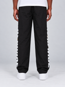 Rear view of men's black Copper Rivet windbreaker sweatpants with nylon fabric and rivet detailing.